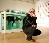 Damien Hirst, posando delante de dos de sus obras