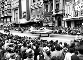 Desfile de vehículos en el marco de una Fiesta de la Locomoción. Avenida 18 de Julio entre las calles Río  Negro y Julio Herrera y Obes. 25 de agosto de 1948.  (Foto: 08322FMHGE.CDF.IMO.UY - Autor: S.d./IMO).